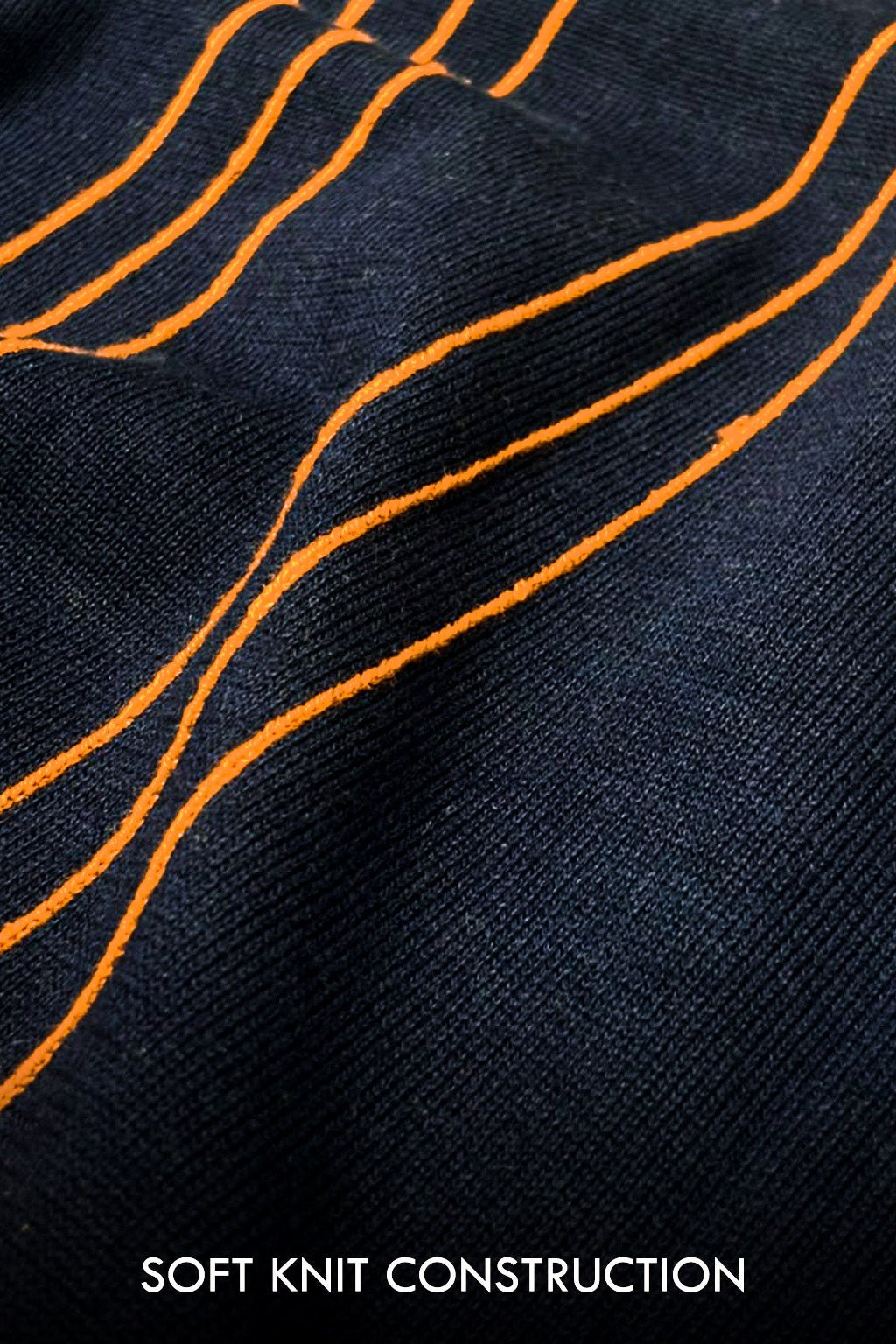 Close-up of a dark navy knit fabric with bright orange wavy stitched lines and the text 'SOFT KNIT CONSTRUCTION' at the bottom.