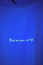 Blue tshirt with white text 'Watch me rise, entirely.'