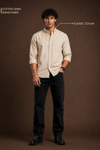A man stands against a brown studio background wearing a light beige long-sleeve button-up shirt with a classic collar and dark pants. Text in the upper left reads 'COTTON-LINEN BLEND FABRIC' and text on the right points to the collar with 'CLASSIC COLLAR'.