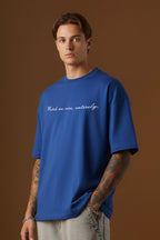 Close-up of blue oversized t-shirt with Watch me rise entirely quote printed on front