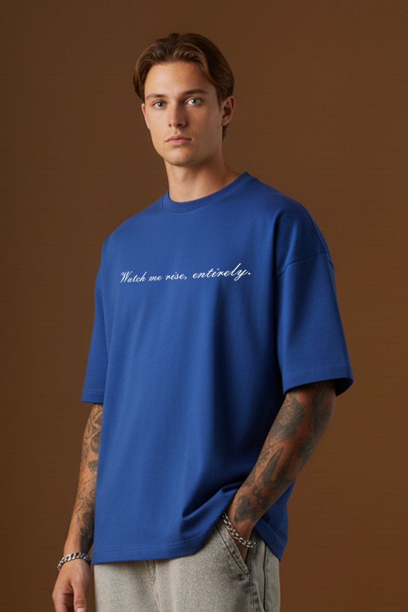 Close-up of blue oversized t-shirt with Watch me rise entirely quote printed on front