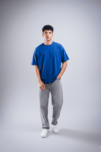 Person wearing a blue t-shirt and gray pants on a plain background