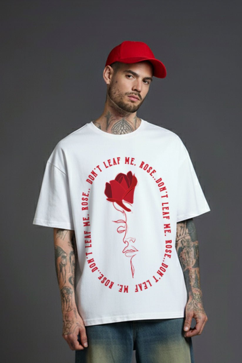 Male model wearing a white oversized cotton t-shirt with a red rose and abstract face line art graphic print, "Don’t Leaf Me Rose" text design, casual streetwear style