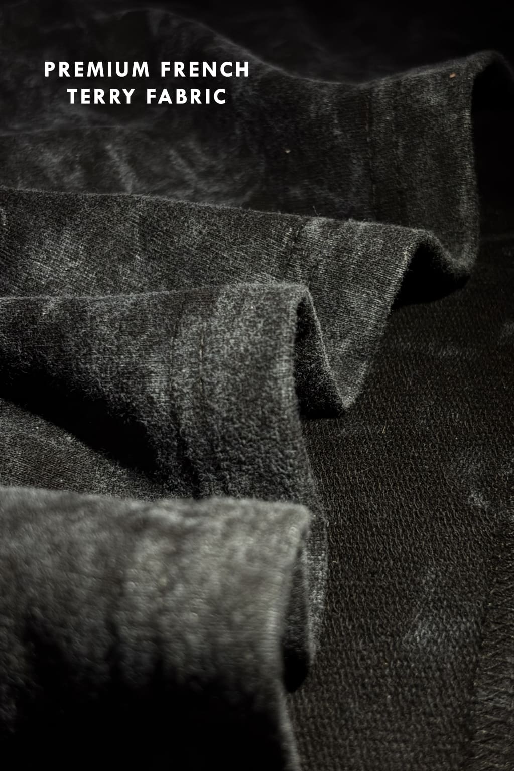 Close-up texture shot of premium French terry 240 GSM fabric with black acid wash finish