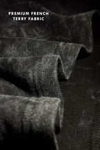 Close-up texture shot of premium French terry 240 GSM fabric with black acid wash finish