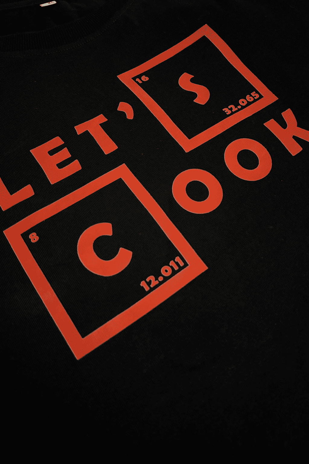 Black t-shirt with red 'Let's Cook' text design on a black background