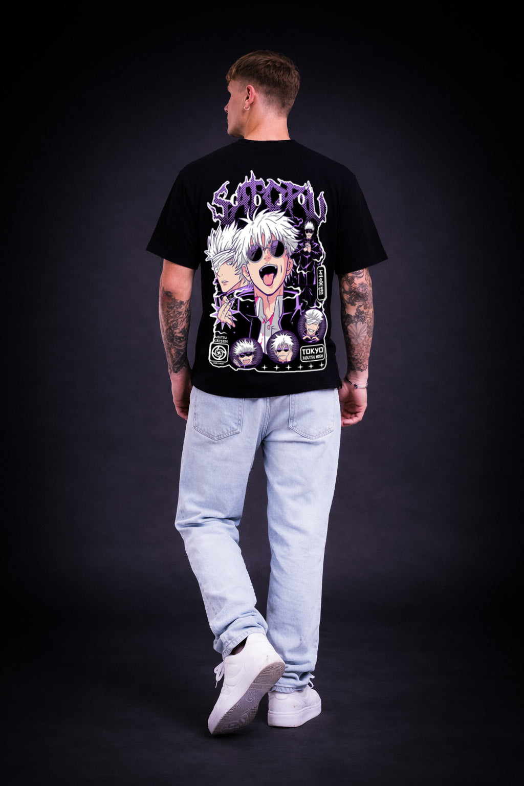 Person wearing a premium quality black t-shirt with a graphic design on the back against a dark background