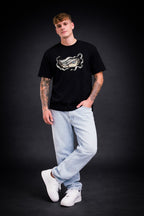 Person wearing a black t-shirt with a graphic design on a dark background