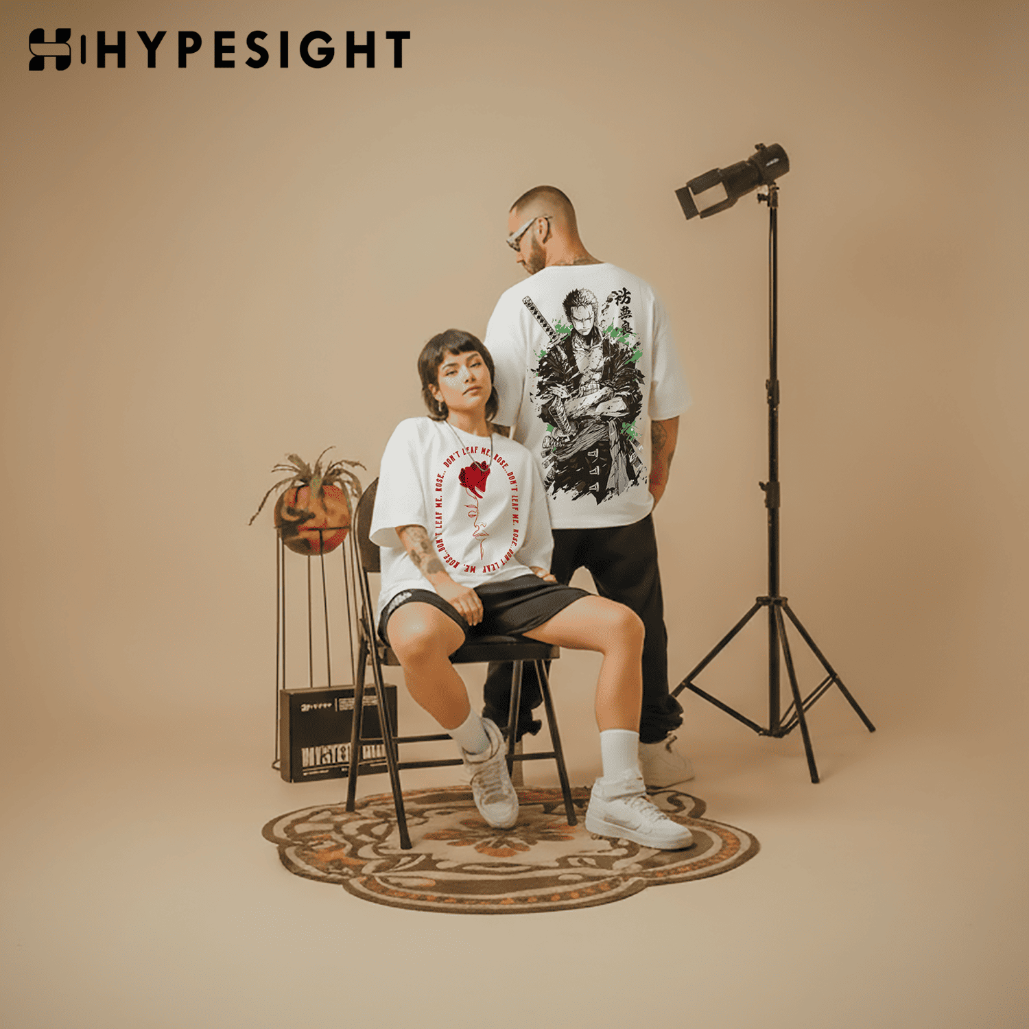 Two people wearing t-shirts with graphic designs in a studio setting, with 'Hypesight' branding.