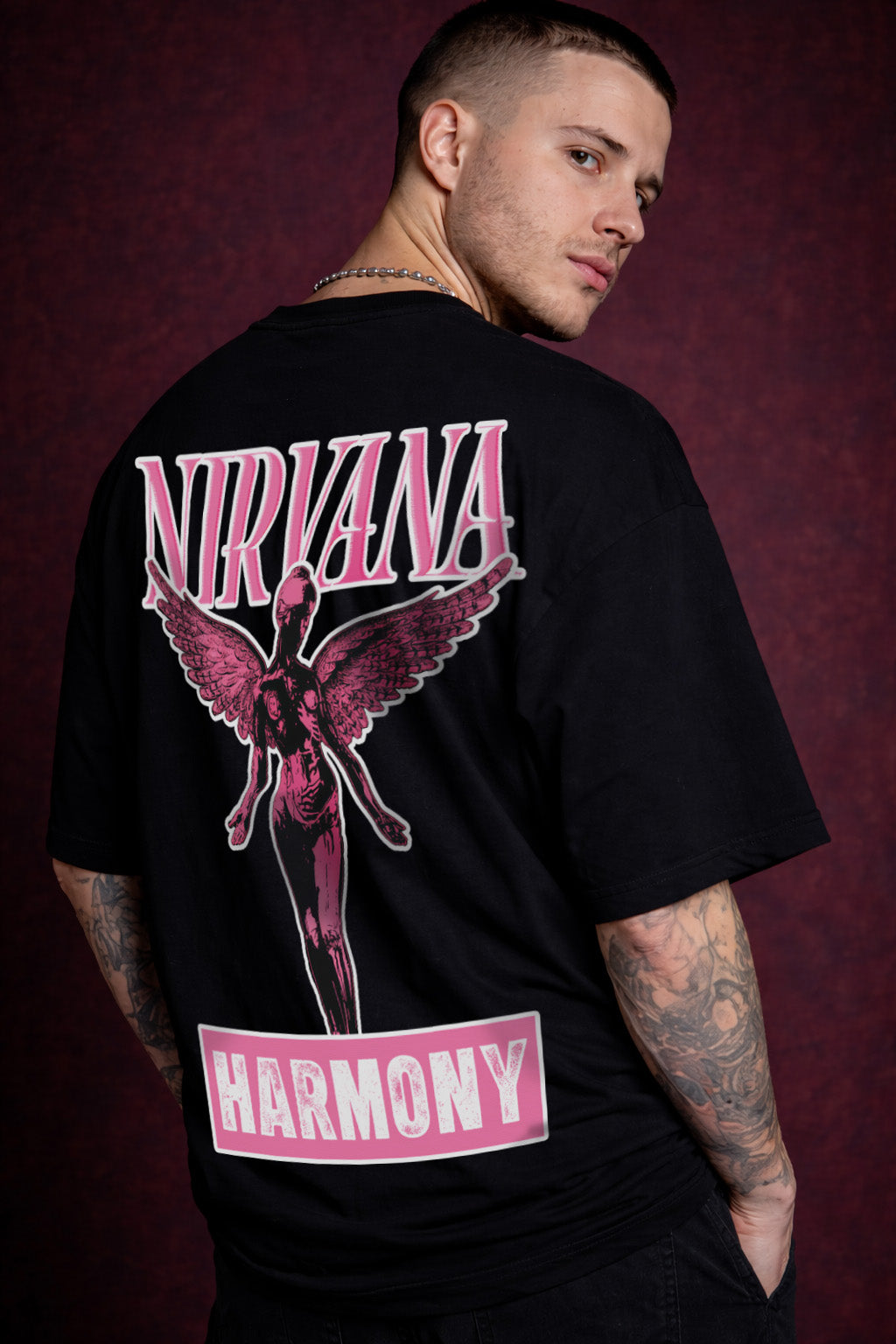 Person wearing a black t-shirt with 'Nirvana' and 'Harmony' design on a dark background