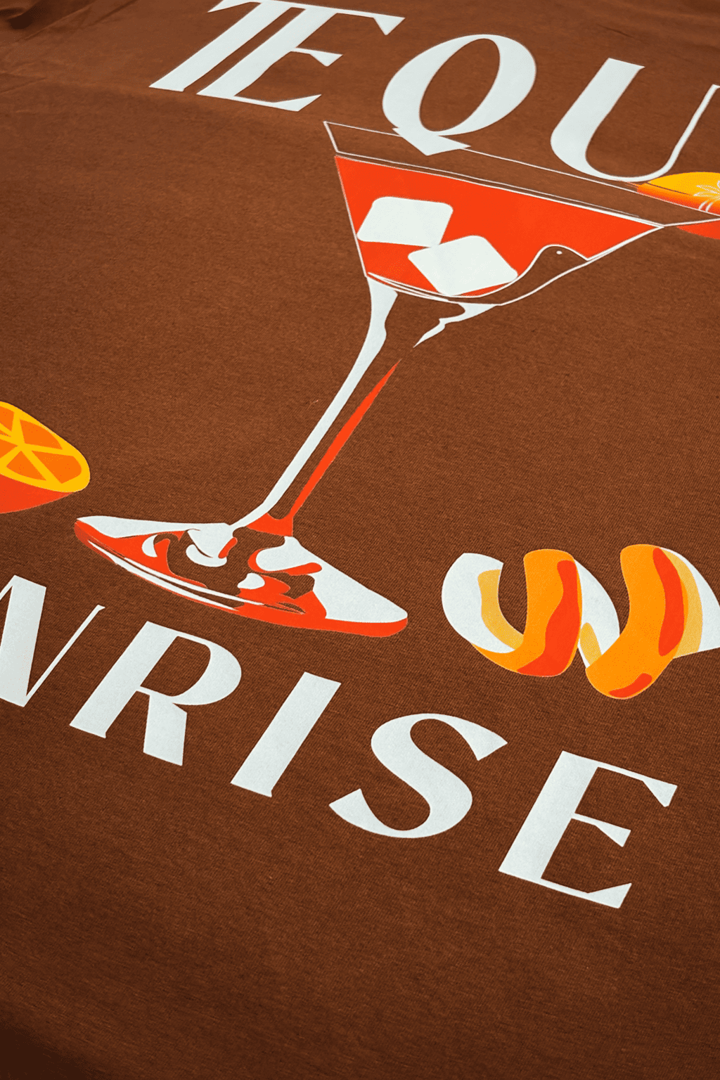 Brown t-shirt with a martini glass graphic and text on a brown background