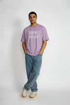 Full front view of Serial Chiller oversized lavender T-shirt styled with jeans and sneakers