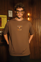 Front close-up of Tequila Sunrise brown oversized T-shirt with small martini glass print