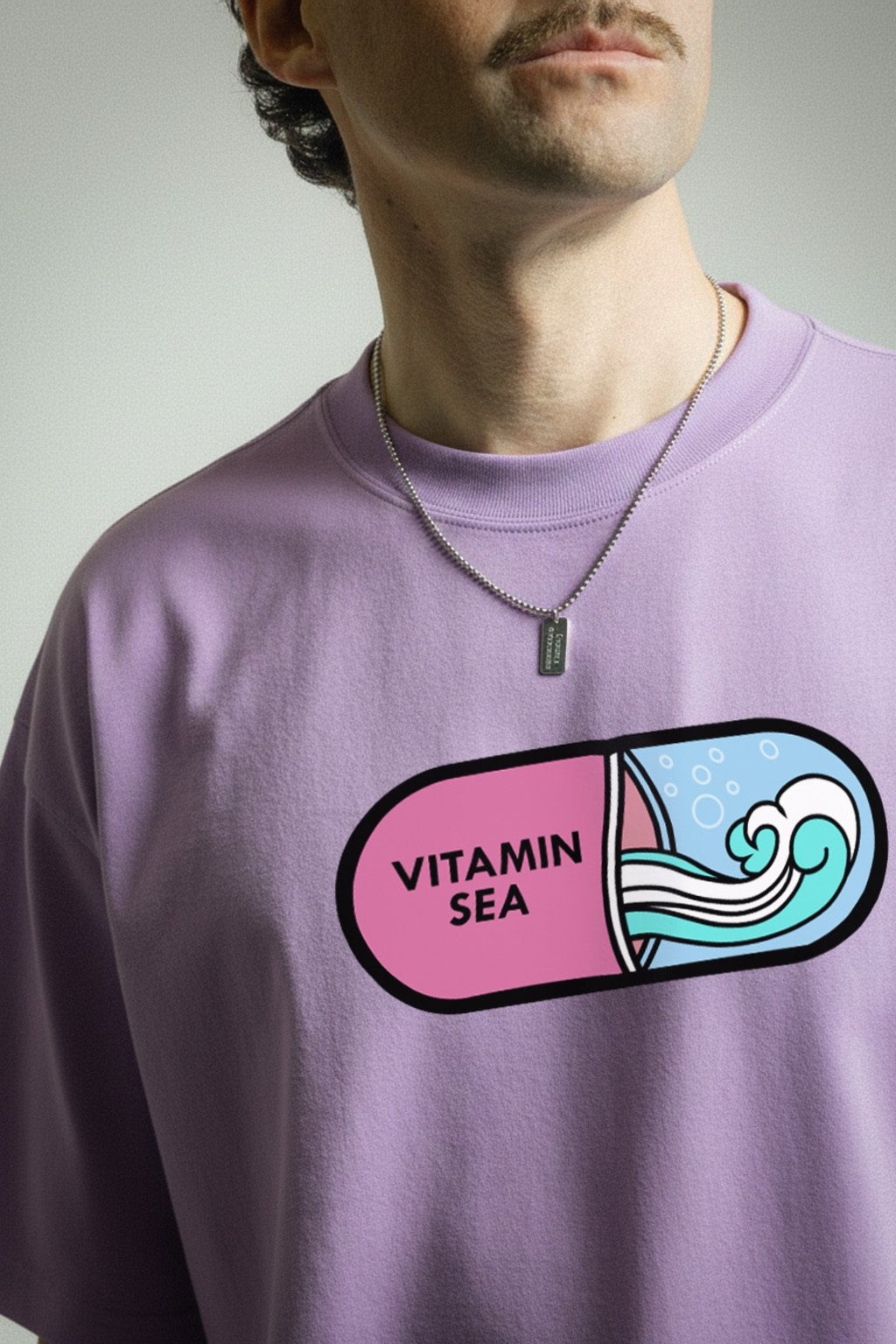 Close-up of Vitamin Sea graphic printed lavender oversized t-shirt for men and women featuring beach and ocean inspired capsule artwork