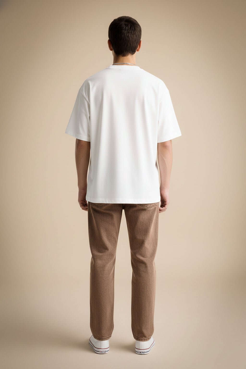 Person wearing a white t-shirt and brown pants on a white background